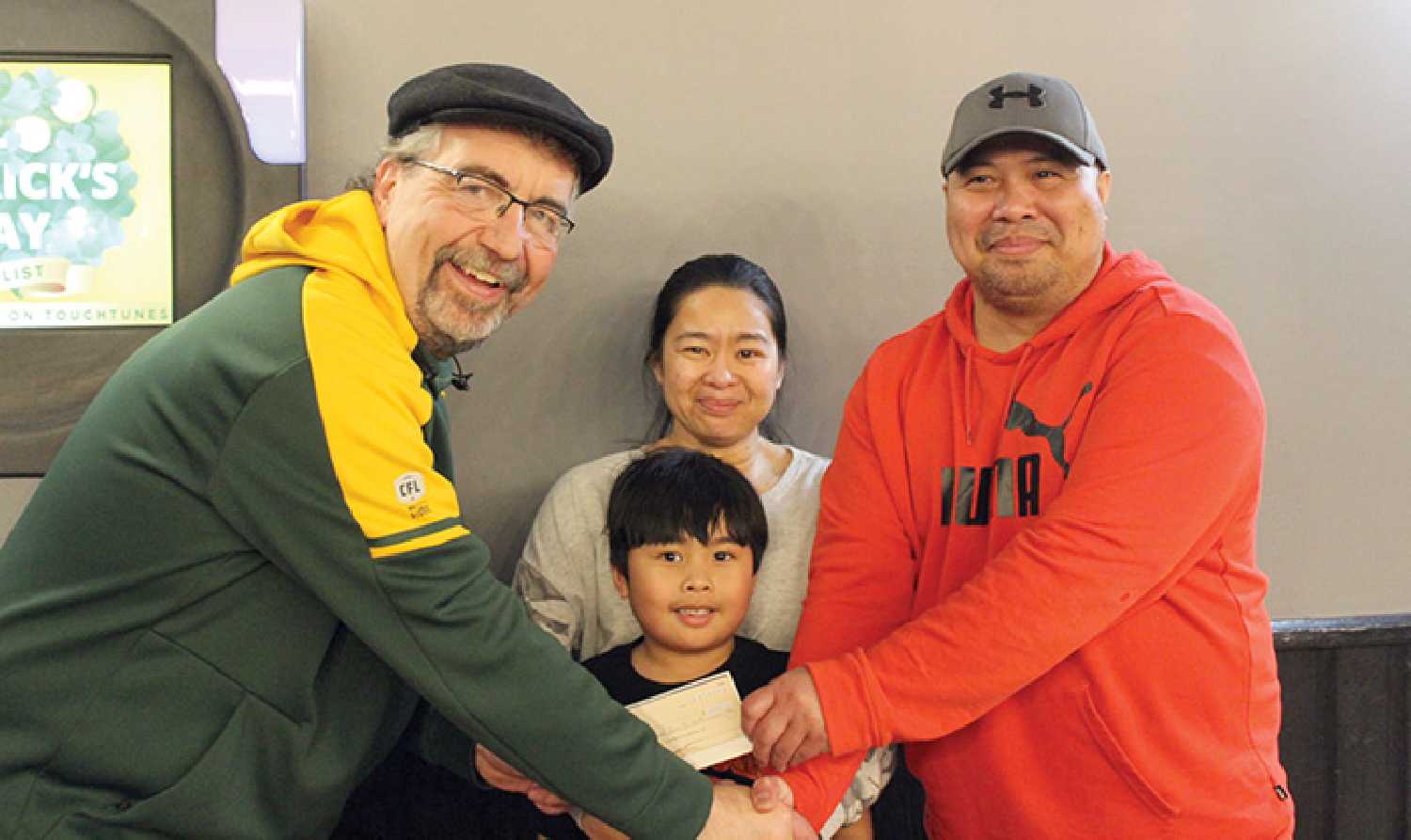 The cheque presentation to the Camile family to help with expenses.  From left is Elks Club Treasurer Ken Shackel, Lara and Adam Camile, and in front is their son Jared. 